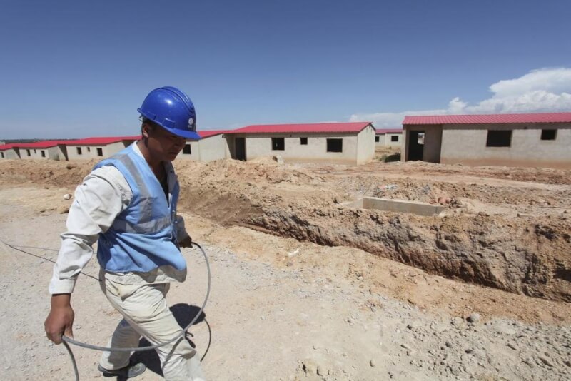 圖為2014年3月5日，一名中國工人走過安哥拉的建築工地。（路透社）
