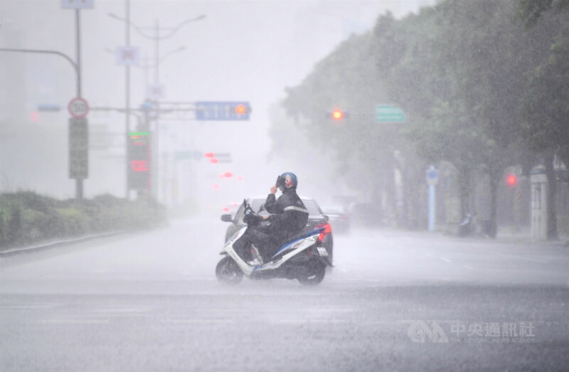 圖為高雄苓雅區午後大雨，機車騎士頂著雨勢前進。（中央社檔案照片）