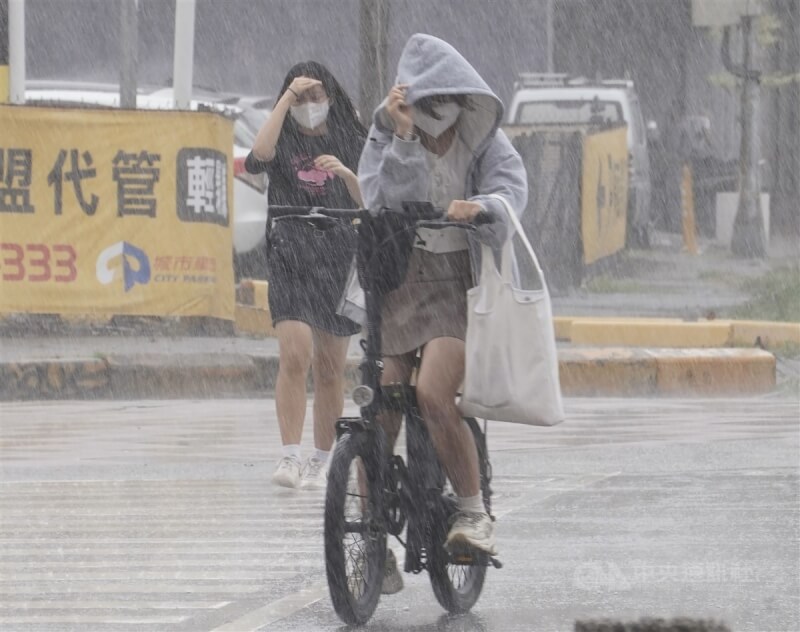 中央氣象局13日下午針對高雄市等多個縣市發布大雨特報，提醒民眾受滯留鋒面影響，易有短延時強降雨發生。圖為高雄市新興區午後降雨，民眾拉緊帽子快步躲雨。中央社記者董俊志攝 112年6月13日