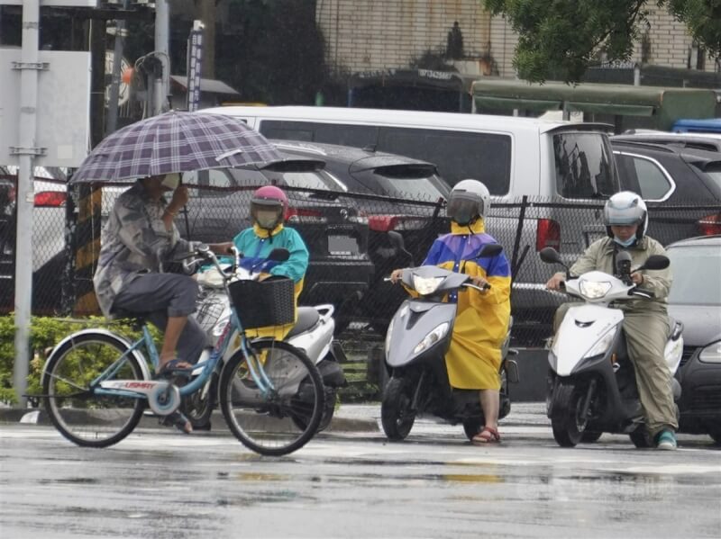 圖為高雄市新興區民眾撐傘騎腳踏車。中央社記者董俊志攝 112年6月15日