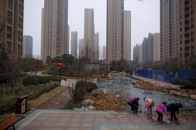 圖為河南省鄭州市，人們在社區池塘邊玩冰塊。（路透社）