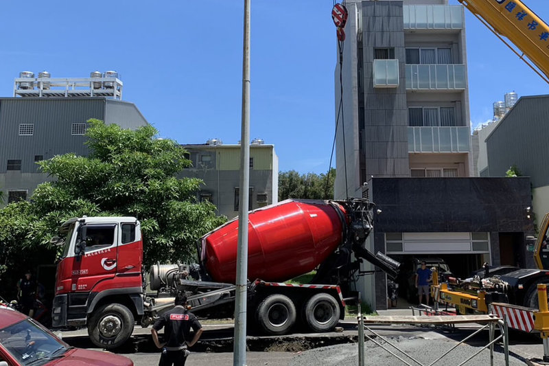 一輛預拌混凝土車20日上午行經台南市安平區府平路近健康四街路段時，左側輪胎處路面突然下陷受困，市府調派吊車前往處理，沒有人員受傷。（市府提供）中央社記者楊思瑞台南傳真 112年6月20日