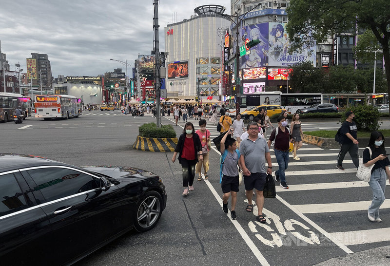 警政署21日晚間原指出，30日起只要斑馬線上有行人，不論遠近，車輛駕駛都要停讓。不過交通部長王國材22日表示，相關規定因太過嚴格，經討論後將暫緩實施，後續會就「行人已在近端駕駛須停讓」方案進行討論，研擬保護行人執法依據。圖為民眾22日午後在台北西門町商圈路口過馬路。中央社記者徐肇昌攝 112年6月22日