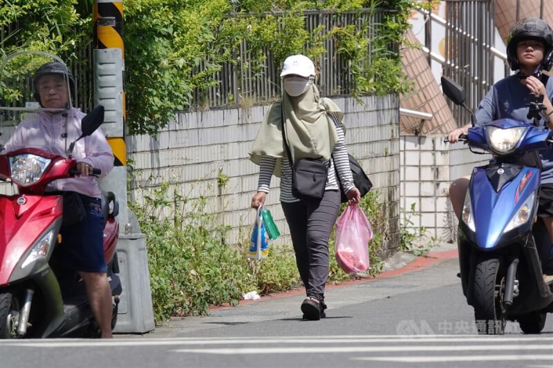 中央氣象局表示，22日白天各地為多雲到晴，午後山區及近山區平地有局部短暫雷陣雨，氣溫方面，各地高溫可來到攝氏32到35度。圖為天氣悶熱，台北市南港區有民眾外出全身包緊緊防曬。中央社記者鄭傑文攝 112年6月22日