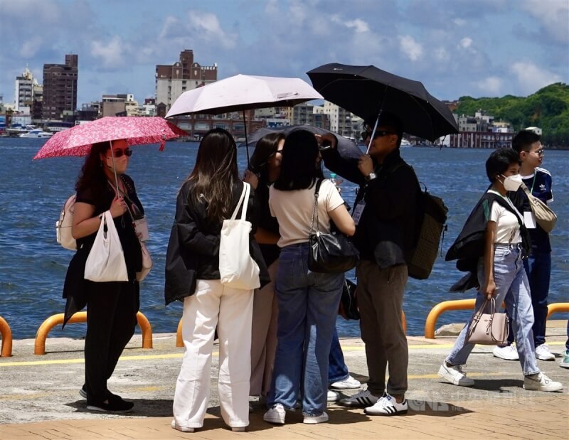 圖為民眾在高雄駁二藝術特區周邊撐傘散步。（中央社檔案照片）