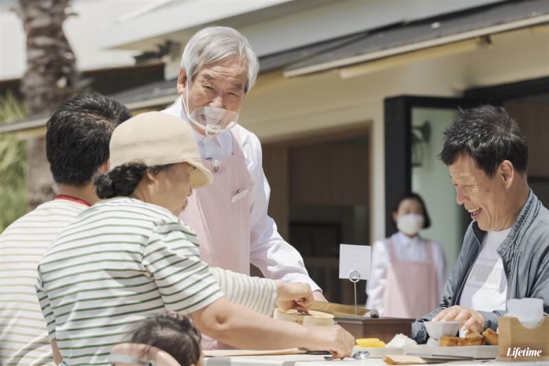 患有阿茲海默症的花甲爺爺在韓國綜藝節目「歡迎光臨花甲食堂」擔任外場服務生,招呼前來用餐的客人。(杰德影音提供)中央社記者葉冠吟傳真 112年6月23日