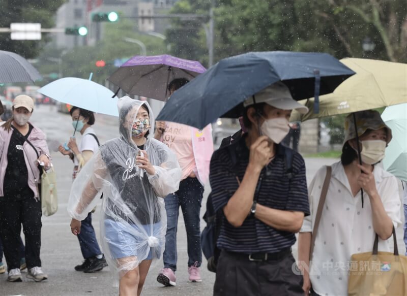 圖為11日北市街頭民眾撐傘、穿雨衣擋雨。（中央社檔案照片）