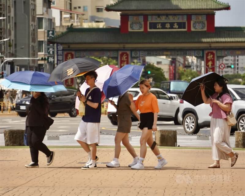 圖為高雄港周邊民眾撐傘遮陽。（中央社檔案照片）