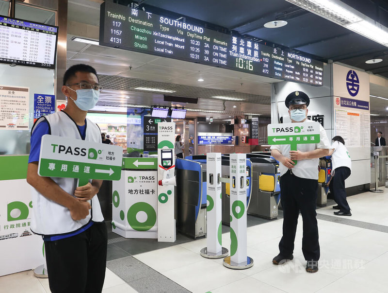 TPASS行政院通勤月票1日正式上路,台鐵台北車站的工作人員拿著指示牌在專用通道前協助、引導民眾。中央社記者謝佳璋攝 112年7月1日