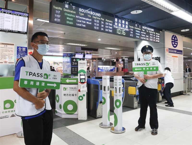 TPASS行政院通勤月票1日正式上路,台鐵台北車站的工作人員拿著指示牌在專用通道前協助、引導民眾。中央社記者謝佳璋攝 112年7月1日