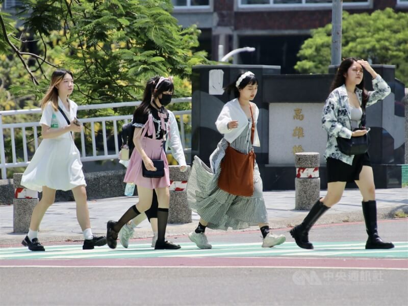 圖為高雄市鹽埕區晴朗炎熱,民眾用手遮擋陽光快步過馬路。(中央社檔案照片)