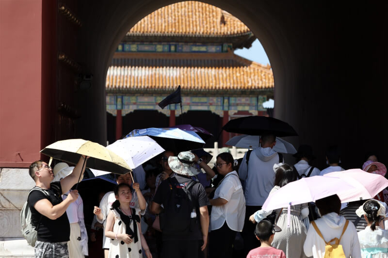 圖為北京連日高溫，民眾撐傘遊覽故宮。（中新社）