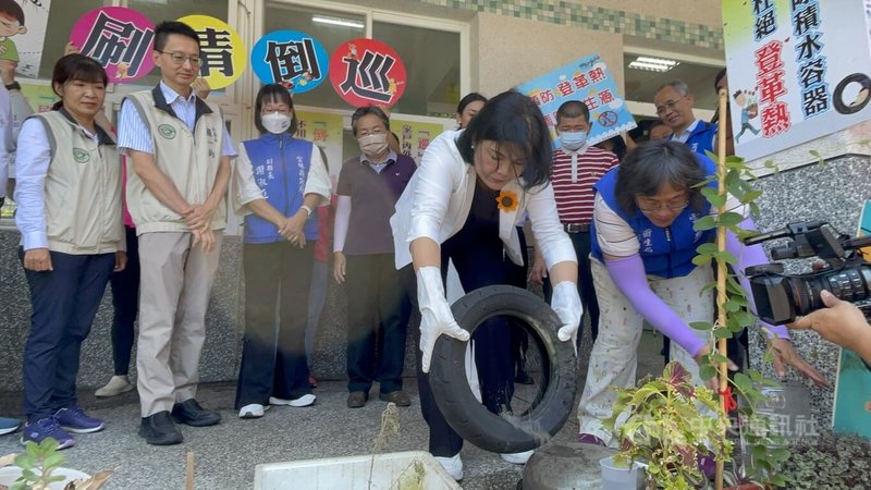 雲林縣登革熱確診再添1例,目前已有7例全集中在古坑鄉,雲林縣長張麗善(拿輪胎者)4日示範防疫口訣「巡、倒、清、刷」4步驟,清除環境孳生源。中央社記者姜宜菁攝 112年7月4日