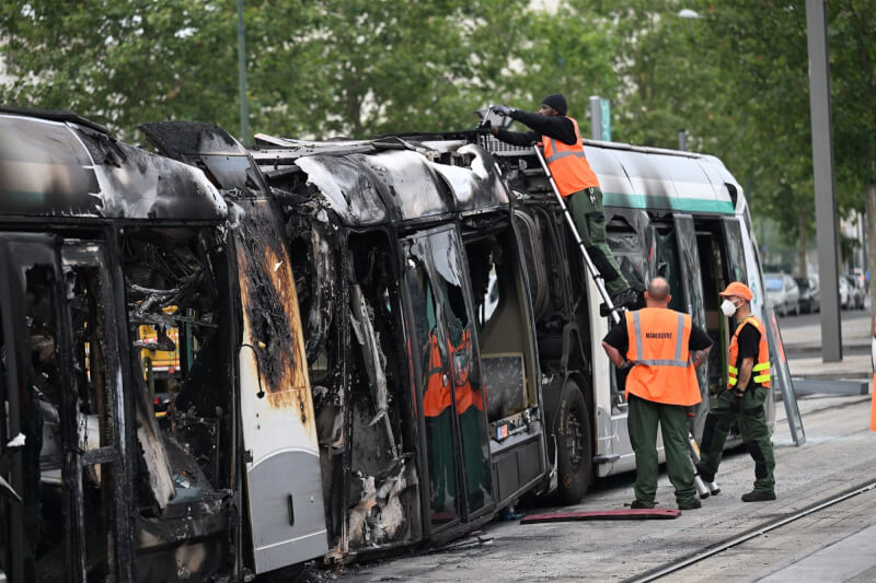 圖為6月29日，民眾在抗議行動中燒毀巴黎西南部克拉瑪特的電車後，相關單位派人協助拆除。（法新社）