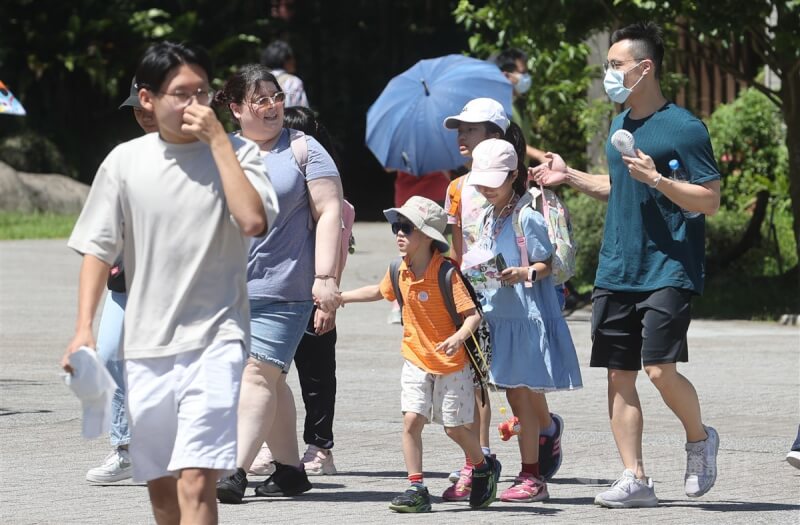 圖為民眾趁天氣晴朗到台北市立動物園遊玩，戴帽子、手持小電扇消暑防曬。中央社記者鄭清元攝 112年7月6日