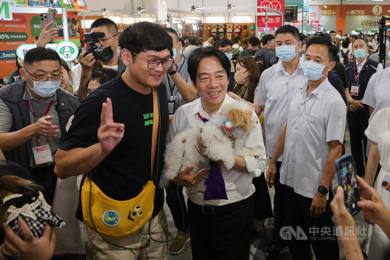 副總統賴清德（前中白衣者）9日下午現身台北南港展覽館參觀「2023展昭台北寵物用品展」，有民眾把握機會帶著寵物和賴清德拍照留念。中央社記者裴禛攝  112年7月9日