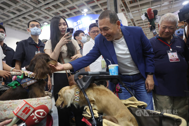 國民黨總統參選人侯友宜（前右2）10日前往台北南港展覽館參觀2023台北寵物用品展，和現場的寵物狗互動。中央社記者王飛華攝  112年7月10日