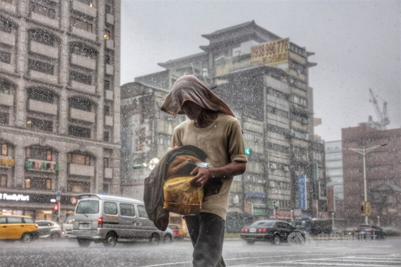 圖為台北市中正區午後下起大雷雨，民眾冒雨前行。（中央社檔案照片）