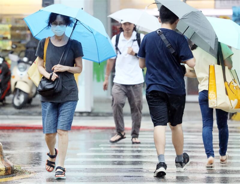 中央氣象局表示，12日白天台北市、南高屏等6縣市仍要防高溫，但午後大台北、中南部地區及其他山區則須留意局部大雨發生。圖為台北市午後降下大雨，民眾撐傘快步過馬路。中央社記者郭日曉攝 112年7月11日