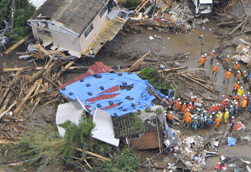 日本九州降大雨，福岡縣久留米市10日許多建築倒塌，消防人員協力救援。（共同社）
