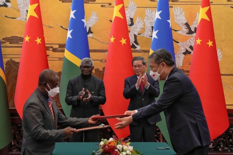 中國和索羅門群島10日簽署一項警務合作協議。圖為兩國交換協議文件，後左為索羅門群島總理蘇嘉瓦瑞，後右為中國國務院總理李強。（路透社）