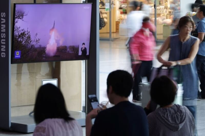 12日南韓民眾觀看北韓發射彈道導彈的新聞報導。（路透社）