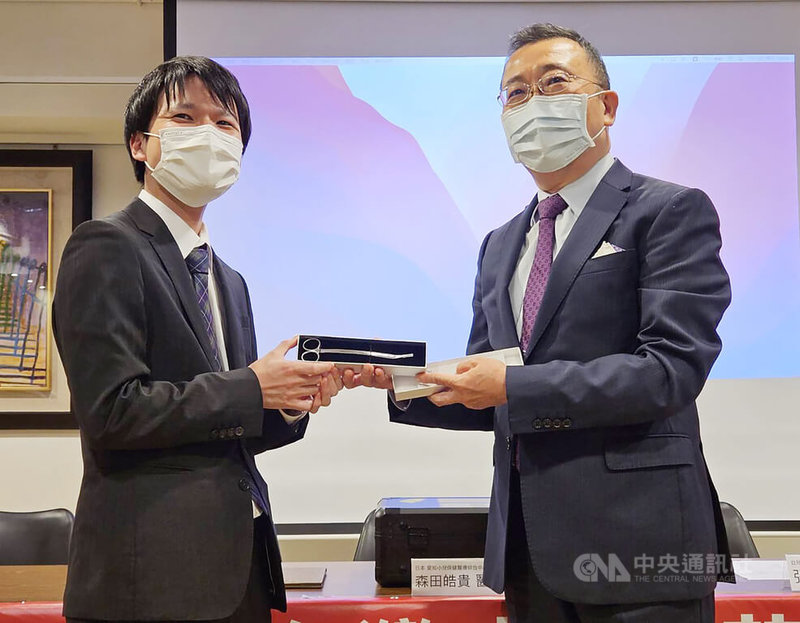 「國際唇顎裂研修醫師訓練計畫」首名外籍醫師結業,圖為台北醫學大學附設醫院附醫顱顏中心主任陳國鼎(右)12日贈送手術工具給來自日本的醫師森田皓貴(左)。中央社記者陳婕翎攝 112年7月12日