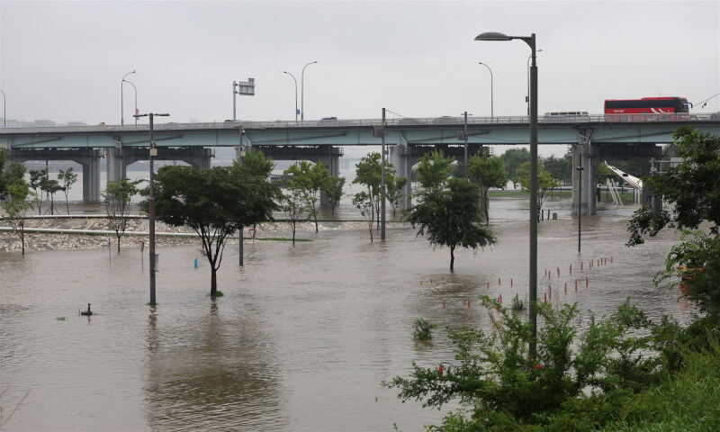 暴雨14日橫掃韓國，導致首都首爾大規模停電，各地上百人撤離家園。圖為首爾漢江公園遭洪水淹沒。（韓聯社）