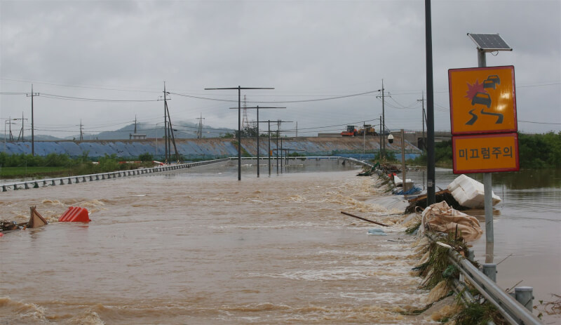 忠清北道河流15日氾濫成災淹沒往來道路。（韓聯社）