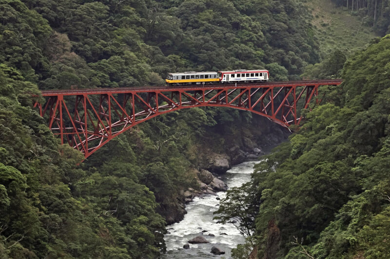 日本南阿蘇鐵道15日在時隔約7年3個月後終於恢復全線行駛。圖為列車行經第一白川橋梁。（共同社）