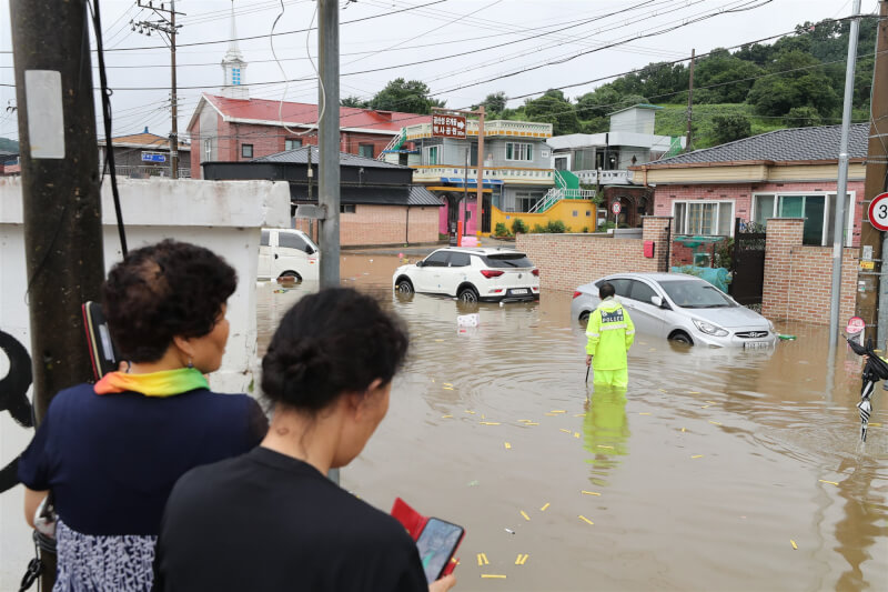 忠清南道地區15日有道路淹成河，路旁停放車輛成泡水車。（韓聯社）