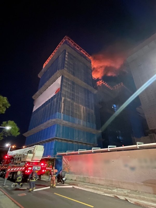 新北市消防局指出，三重區仁義街一處建築工地15日晚間發生火警，建築第14樓全面燃燒，但無人受困，消防人車已到場搶救中。（新北市消防局提供）中央社記者黃旭昇新北市傳真  112年7月15日