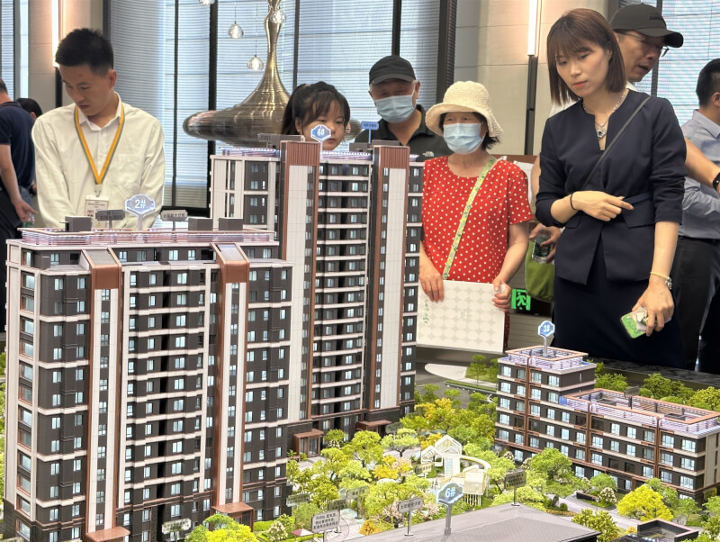 圖為北京民眾6月24日觀看建案大樓模型。（中新社）
