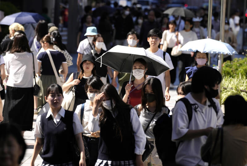 日本東部和西部受高氣壓籠罩影響，17日全國觀測到氣溫逾攝氏35度的地方多達195處，是今年最多紀錄。圖為名古屋站前撐陽傘的民眾。（共同社）