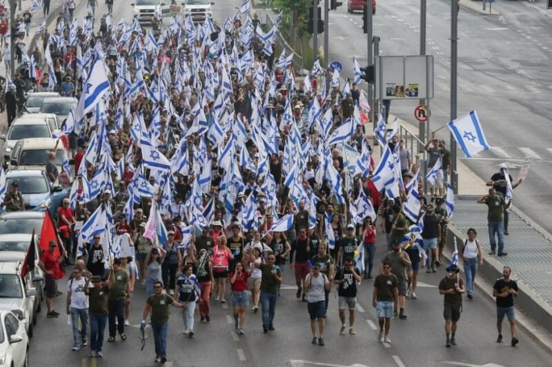 以色列國會將就政府的司法改革計畫進行投票，抗議民眾18日在特拉維夫公路上遊行，並阻擋軍事總部的入口。（路透社）