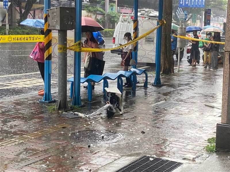 新北市板橋區20日一處大樓安裝冷氣掉落砸死等公車女子。政治大學稍晚表示，發生憾事的是財政系學生。圖為事發現場拉起封鎖線，機體殘骸散落地面。中央社記者黃旭昇攝 112年7月20日