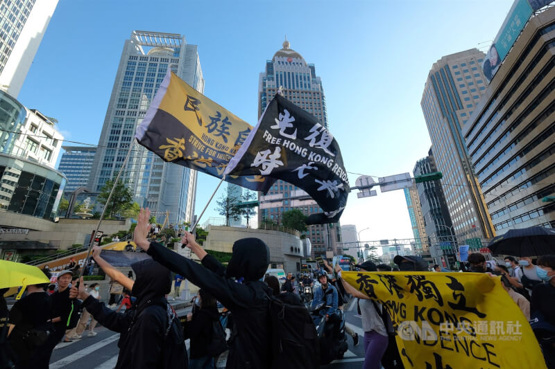 圖為民眾在北市信義區揮舞「光復香港時代革命」旗幟。（中央社檔案照片）