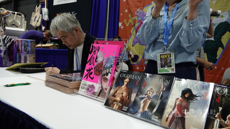 漫畫家常勝在聖地牙哥動漫展（San Diego Comic-Con）台灣書院的攤位上為讀者簽名。攤位上放置的是常勝作品「閻鐵花」及「奧德曼」（OLDMAN）。中央社記者林宏翰聖地牙哥攝 112年7月22日