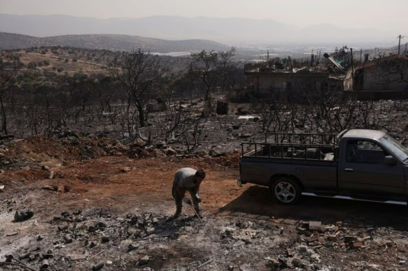 21日一名希臘男子的房屋遭森林野火燒毀。（路透社）