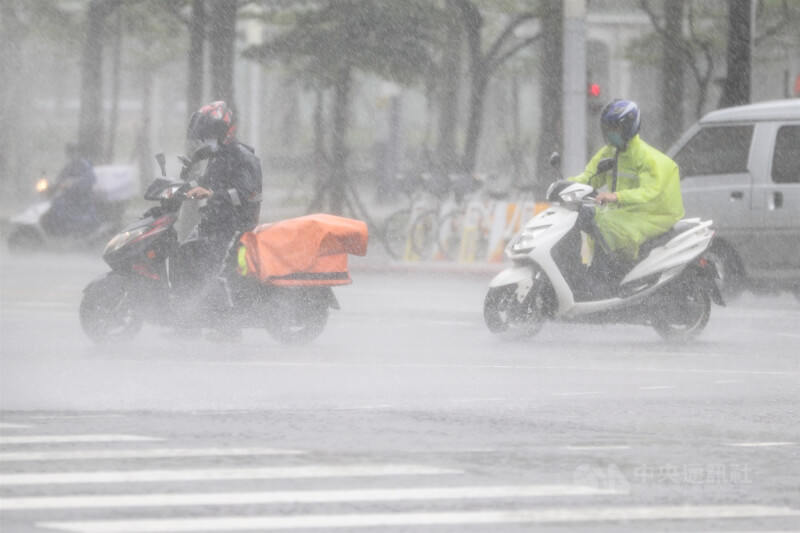 圖為騎士上午在台北市信義區冒著大雨騎車。（中央社檔案照片）