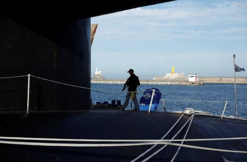 圖為美軍潛艦「肯塔基號」停在韓國釜山海軍基地，一人在船上巡邏。（路透社）