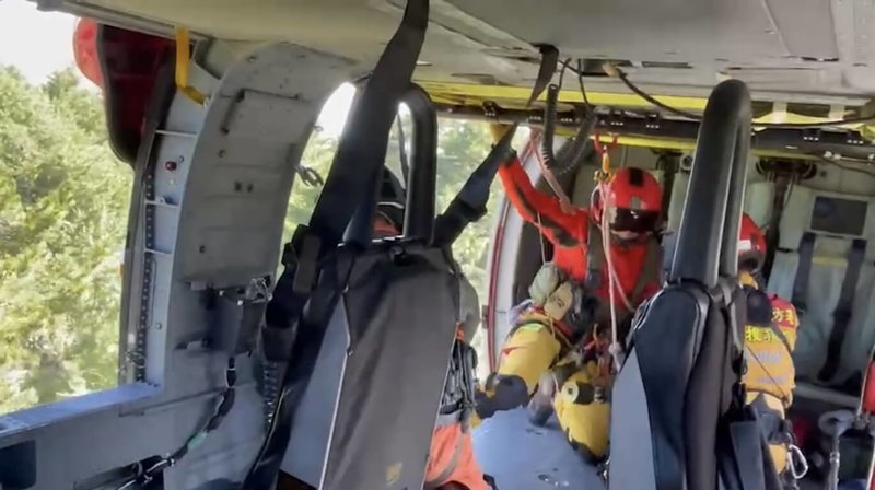 一行4人登山隊伍23日從宜蘭縣南山部落可法橋入山，其中2名山友不慎跌落邊坡，右腳腫脹無法行走，且有高山症狀，花蓮空勤獲報後出動直升機將2人吊掛下山送醫。（空勤總隊提供）中央社記者張祈傳真  112年7月25日