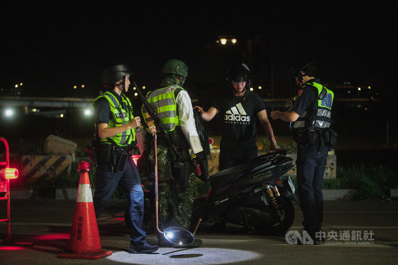 為演練重要聯外道路防衛，軍警25日深夜於河濱模擬萬板大橋的阻絕設置，並出動金屬探測器偵測有無爆裂物。中央社記者游凱翔攝 112年7月26日