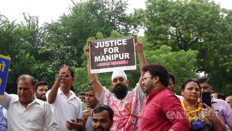 印度小老百姓黨（AAP）25日在新德里發動示威，聲援曼尼普爾省（Manipur）在種族暴亂期間受害的婦女。圖為一名男性示威者身穿「血衣」，高舉「給曼尼普爾正義」字牌。中央社記者林行健新德里攝 112年7月26日