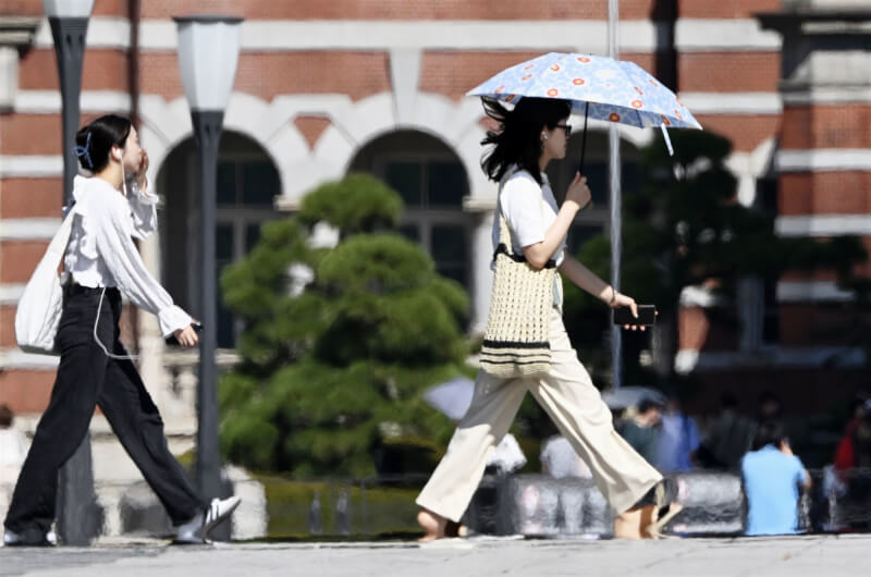日本氣象廳指出將出現「十年一遇」程度的酷暑。圖為東京車站周圍的行人。（共同社）