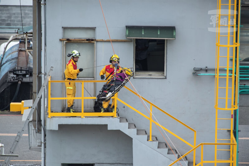 消防人員模擬自建築物中撤離傷員。(軍聞社提供)