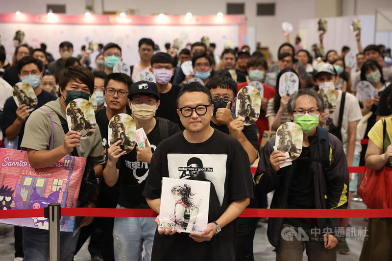 2023年漫畫博覽會27日至31日在台北世貿展覽館一館登場,漫畫「火鳳燎原」作者陳某(前中)受邀舉行簽名會,並與讀者合影。中央社記者王飛華攝 112年7月27日