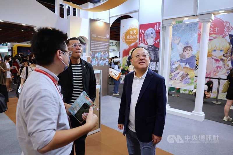 文化部長史哲（右）27日上午到台北世貿一館參觀第22屆漫畫博覽會，圖為史哲在攤位上聽取介紹。中央社記者王飛華攝  112年7月27日