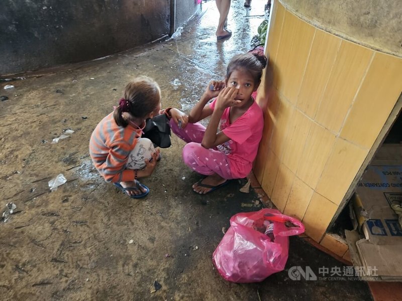 東馬沙巴拿篤漁市場內人聲鼎沸，魚販大聲吆喝賣魚，但兩名無國籍孩童靜靜地蹲在市場一隅。中央社記者黃自強沙巴攝 112年7月29日