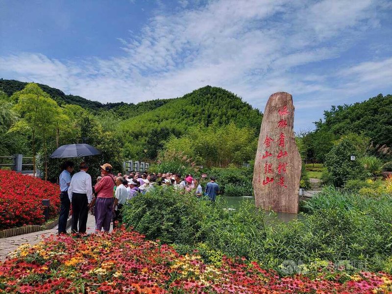 中共總書記習近平還是浙江省委書記時，2005年在浙江湖州市安吉縣余村說出「綠水青山就是金山銀山」，被稱為「兩山理論」。當地將此金句刻寫在大石上，成為地標。來訪遊客與各級幹部大多在此留影。圖為6月29日的余村。中央社記者張淑伶上海傳真  112年7月30日